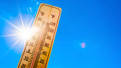 Thermometer with sun and blue sky in the background