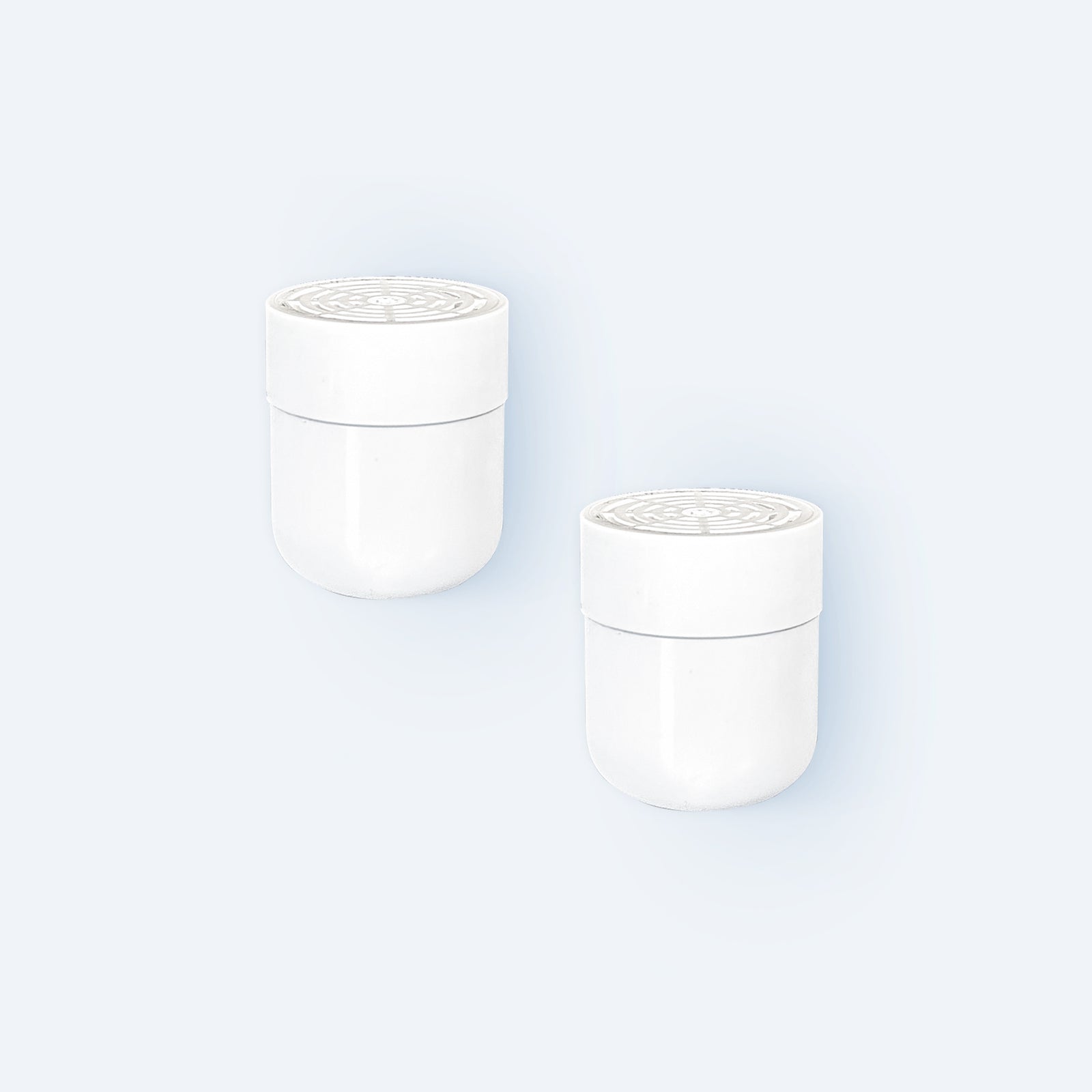 Photo of two in-line shower filter replacement filters on light grey background