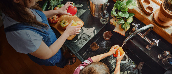 A photo of a mom and boy washing vegetables, using clean, filtered water.