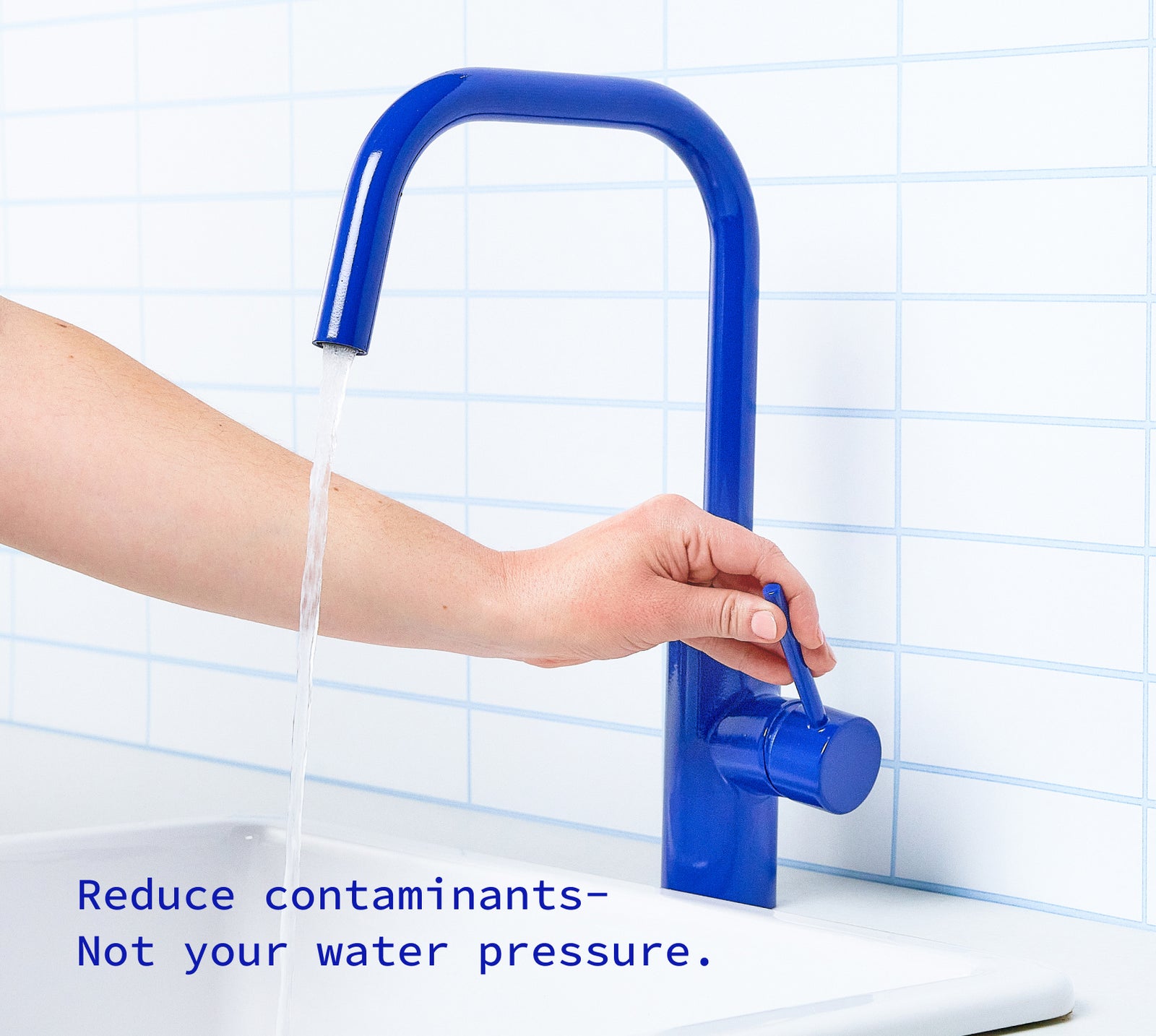 Hand turning on the kitchen faucet with fast water flow.