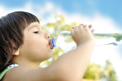 young child drinking bottled water