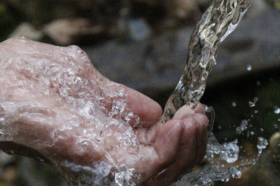 Persons hand catching flowing water