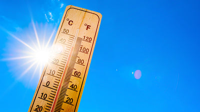 Thermometer with sun and blue sky in the background