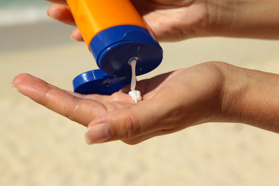 Sunscreen going onto woman's hand at the beach