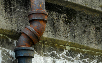 Older water pipe on side of building 