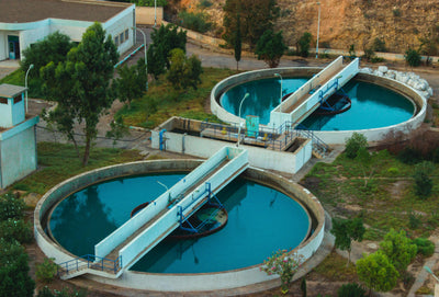 Aerial view of a municipal water treatment plant with circular settling tanks