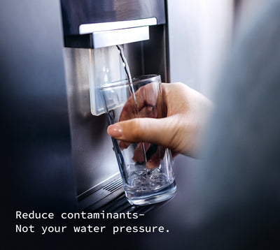 A photo of a hand holding a glass under the fridge water spout.