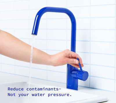 Hand turning on the kitchen faucet with fast water flow.